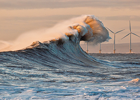 March - A huge wave in the foreground with wind turbines on the horizon
